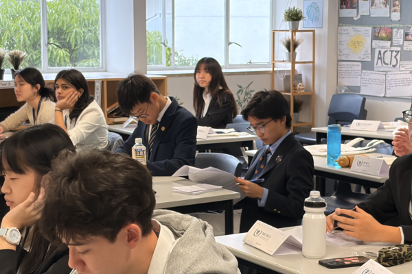 同學在會議期間閱讀資料準備